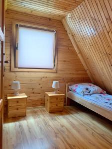 ein Schlafzimmer mit einem Bett und zwei Nachttischen in der Unterkunft Rega domki in Sarbinowo