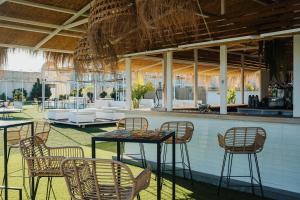 a patio with chairs and tables and a bar at Hotel Puerto Sherry in El Puerto de Santa María