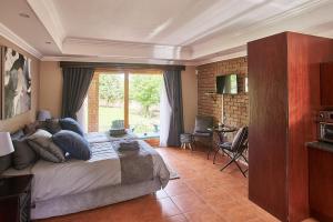 - une chambre avec un lit et une grande fenêtre dans l'établissement Eden Self Catering Clarens, à Clarens