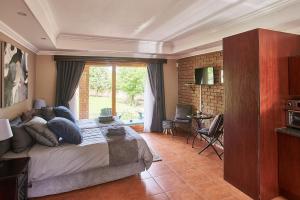 Un dormitorio con una cama y una ventana grande. en Eden Self Catering Clarens, en Clarens