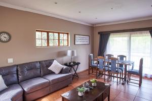 una sala de estar con un sofá y una mesa en Eden Self Catering Clarens, en Clarens