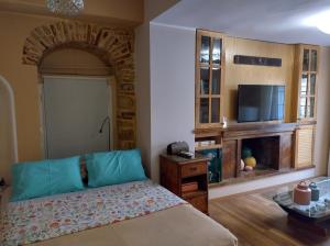 a bedroom with a bed and a flat screen tv at MASTIXI Colors in Chios