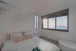 מיטה או מיטות בחדר ב-Beachfront apartment with breathtaking sea view