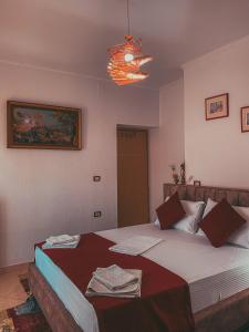 Un dormitorio con una cama grande y una lámpara de araña. en Guest House Juald en Gjirokastër
