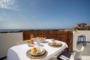 una mesa blanca con platos de comida en el balcón en Coral By Albufeira Rental, en Albufeira