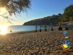 a sandy beach with umbrellas and the ocean at L' APPARTAMENTO sul MARE in Agnone Bagni