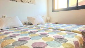 una cama con una colcha colorida en un dormitorio en Restingolita, en La Restinga