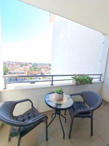 d'un balcon avec une table, deux chaises et une fenêtre. dans l'établissement VUCETIC Apartment- Podgorica, à Podgorica
