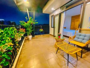 patio con sofá y sillas en el balcón en Hana Hotel & Apartment Da Nang, en Da Nang