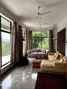 a living room with two couches and windows at Zio legacy Beautiful 3 BHK Villa in Karjat in Murbād