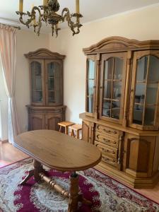 a living room with a table and a china cabinet at Konstancin-Jeziorna Wilanowska in Konstancin-Jeziorna