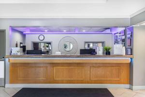 a bar at a restaurant with purple lighting at Travelodge by Wyndham Miramichi New Brunswick in Miramichi