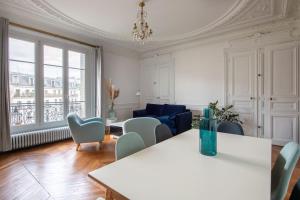 a living room with a table and chairs and a couch at République - Magnifique appartement au centre de Paris in Paris