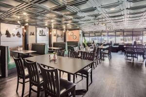 a restaurant with tables and chairs in a room at Travelodge by Wyndham Miramichi New Brunswick in Miramichi