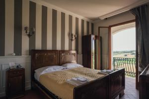 Un dormitorio con una cama y un balcón. en Locanda Dolcevita, en Dozza