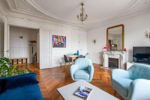 a living room with blue chairs and a fireplace at République - Magnifique appartement au centre de Paris in Paris