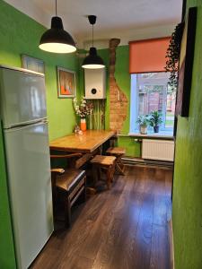 a kitchen with a wooden table and green walls at Riga Latvia couzy apartment by Gucha FREE PARKING AVAILABLE in Riga