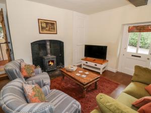 sala de estar con 2 sofás y chimenea en Grove Cottage, en Leominster
