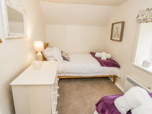 Habitación pequeña con cama y ventana en Grove Cottage, en Leominster