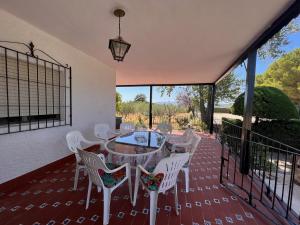 a patio with a table and chairs on a deck at Villa con piscina y jardines privados in Bullas