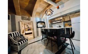 a kitchen and living room with a table and chairs at Charming Townhouse Prime Area Valletta in Valletta