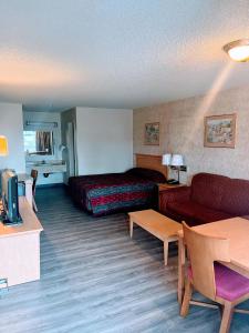 a hotel room with a bed and a couch at Western Inn Lakewood in Lakewood