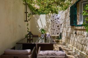 een patio met een tafel en stoelen op een stoep bij Just a step to the Old city gates in Dubrovnik