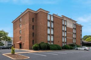 un edificio de ladrillo con coches aparcados en un aparcamiento en Best Western Hampton Coliseum Inn, en Hampton