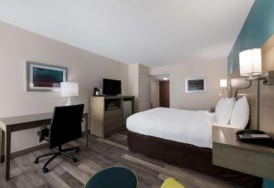 Habitación de hotel con cama y escritorio con ordenador en Best Western Hampton Coliseum Inn, en Hampton