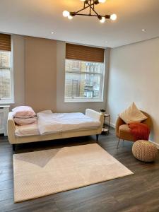 a bedroom with a bed and a chair and a window at Luxury 2 Bedroom Marylebone Apartment in London
