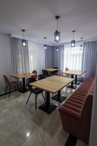 ein Wartezimmer mit Tischen, Stühlen und Fenstern in der Unterkunft D&D Relax SPA Bucovina in Câmpulung Moldovenesc