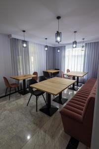 a waiting room with tables and chairs and windows at D&D Relax SPA Bucovina in Câmpulung Moldovenesc