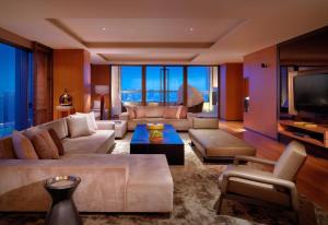 a living room with a couch and a tv at Hyatt Regency Tianjin East in Tianjin