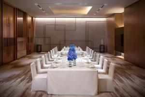 a conference room with a long table with white chairs at Hyatt Regency Tianjin East in Tianjin