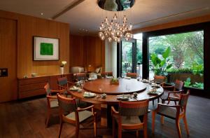 une salle à manger avec une table, des chaises et un lustre dans l'établissement Hyatt Regency Tianjin East, à Tianjin