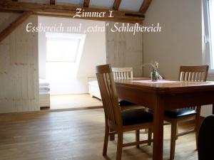 a dining room with a wooden table and chairs at Alte Kass in Neidlingen