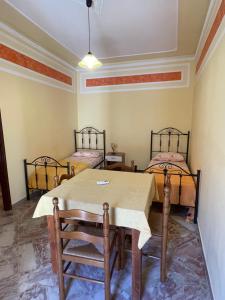 a dining room with a table and two beds at U Curtigliu apartment in Realmonte