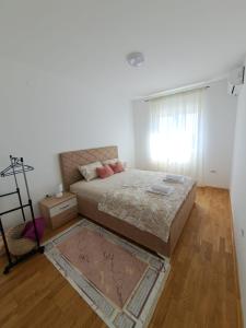 - une chambre avec un grand lit et une fenêtre dans l'établissement VUCETIC Apartment- Podgorica, à Podgorica