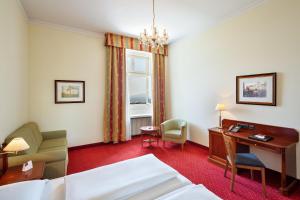um quarto de hotel com uma cama e uma secretária em Austria Trend Hotel Schloss Wilhelminenberg Wien em Viena