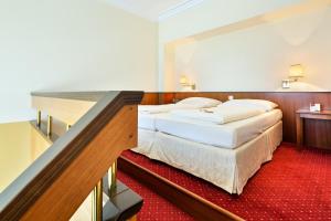 um quarto de hotel com duas camas e uma escada em Austria Trend Hotel Schloss Wilhelminenberg Wien em Viena