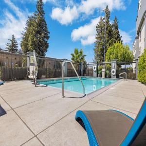 une piscine entourée d'une clôture métallique. dans l'établissement Hampton Inn & Suites Modesto - Salida, à Modesto