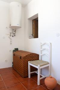uma cadeira e um espelho num quarto em Casa dos Marianinhos em Elvas