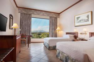 Habitación de hotel con 2 camas y ventana grande. en Hyatt Regency Yogyakarta, en Yogyakarta