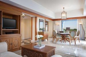 een woonkamer met een tafel en stoelen en een televisie bij Hyatt Regency Yogyakarta in Yogyakarta