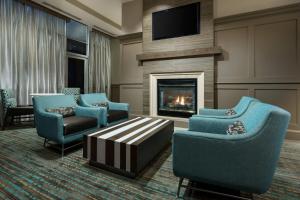 a living room with blue chairs and a fireplace at Residence Inn Houston Downtown/Convention Center in Houston