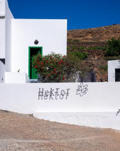 Un edificio bianco con un cartello che dice "Hector" di Hektor - farm, arts & suites a Teguise