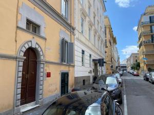 uma rua com carros estacionados ao lado de um edifício em Laura Apartment em Roma