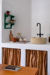 a kitchen counter with a sink and a table at Hektor - farm, arts & suites in Teguise