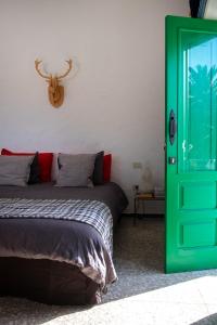 a bedroom with a green door and a bed at Hektor in Teguise