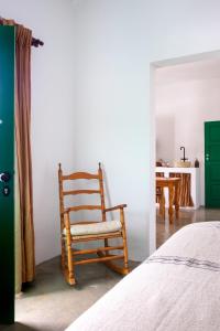 a rocking chair in a bedroom with a table at Hektor - farm, arts & suites in Teguise